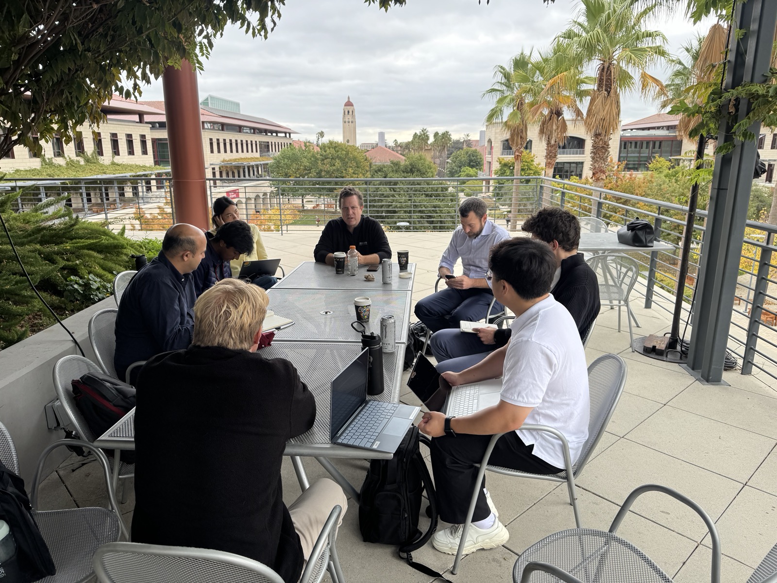SCV students and a mentor meeting on a Stanford terrace with Hoover Tower behind
